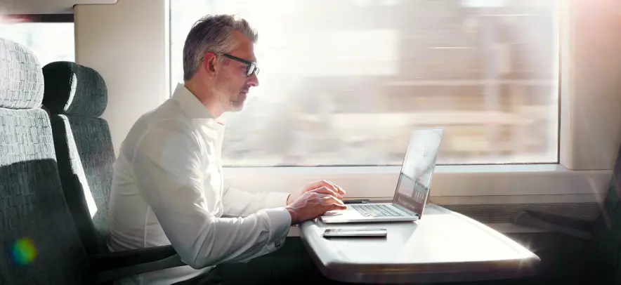 Homem trabalhando no computador em um trem